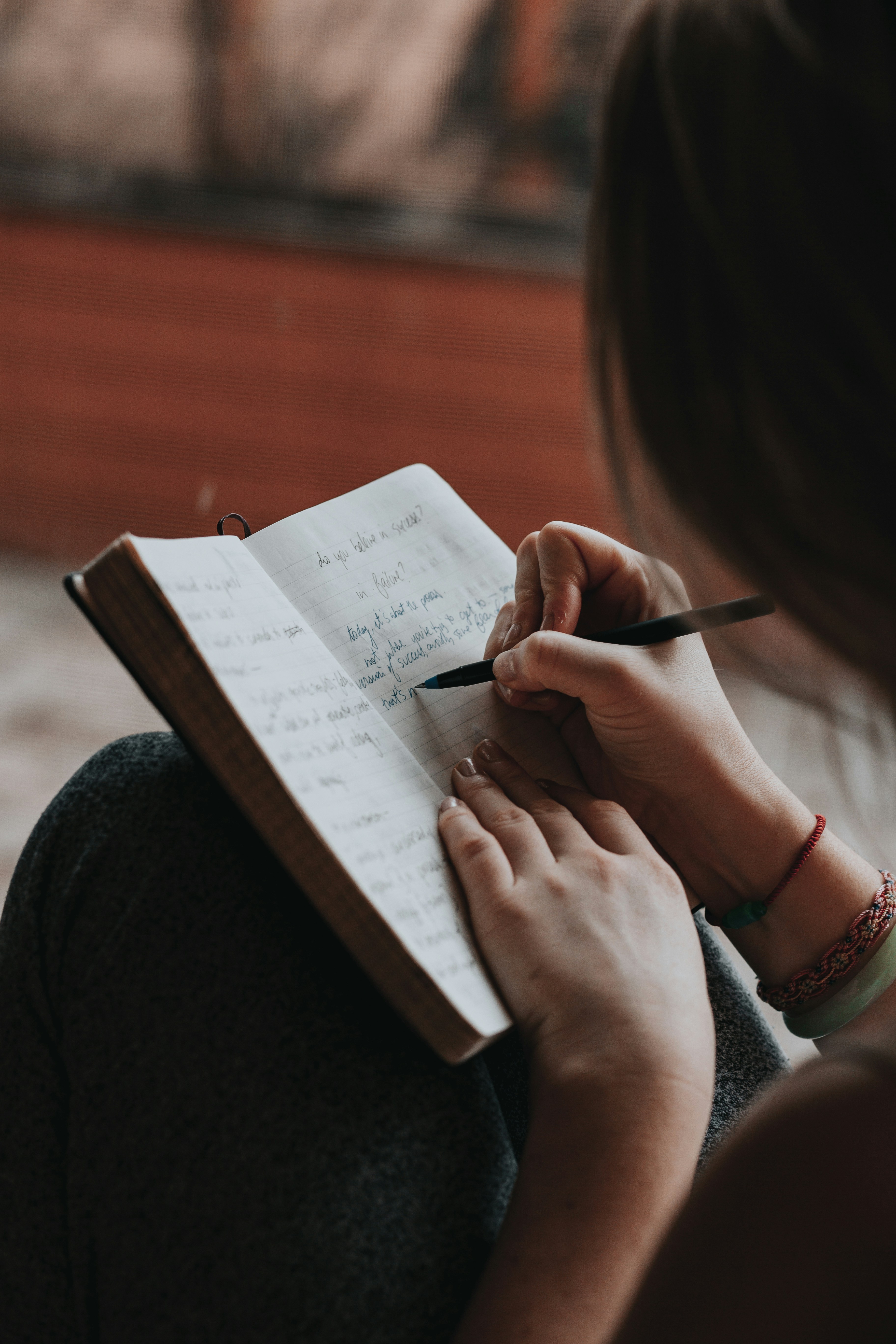Hands writing in a journal