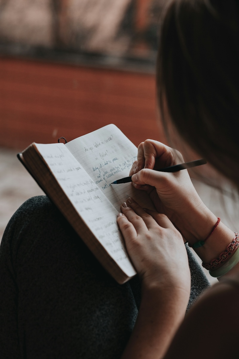 Hands writing in a journal